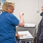 Vet nurse Jenny advising a senior cat owner in the practice at Hook Norton Veterinary Group