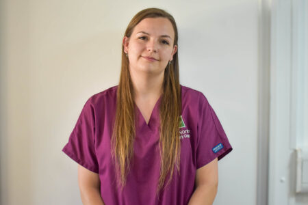 Rebecca Duerden, Hook Norton Veterinary Group team member, in a maroon scrub top