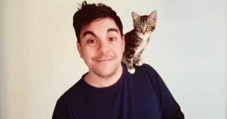 John Athanasiou, Hook Norton Veterinary Group team member, with a kitten perched on his shoulder